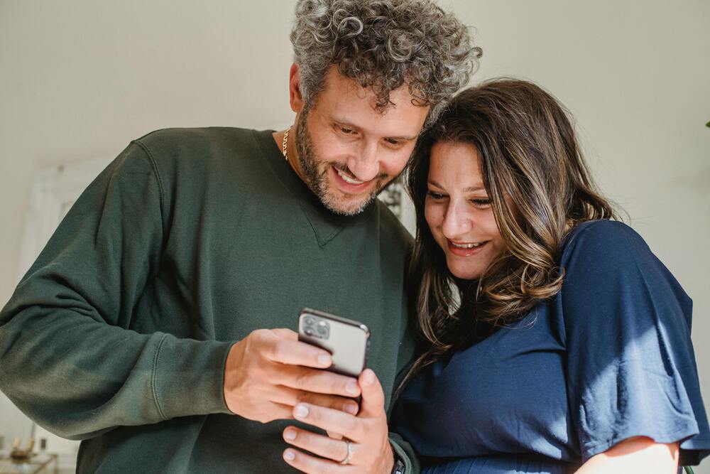Pareja mirando un celular para confirmar una reserva